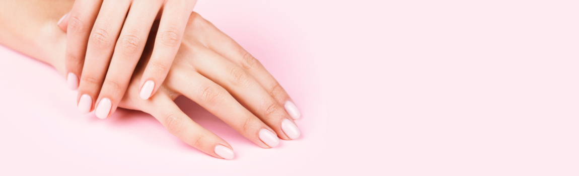 Female's hands with classic pastel manicure on pink background. Banner for beauty salon.